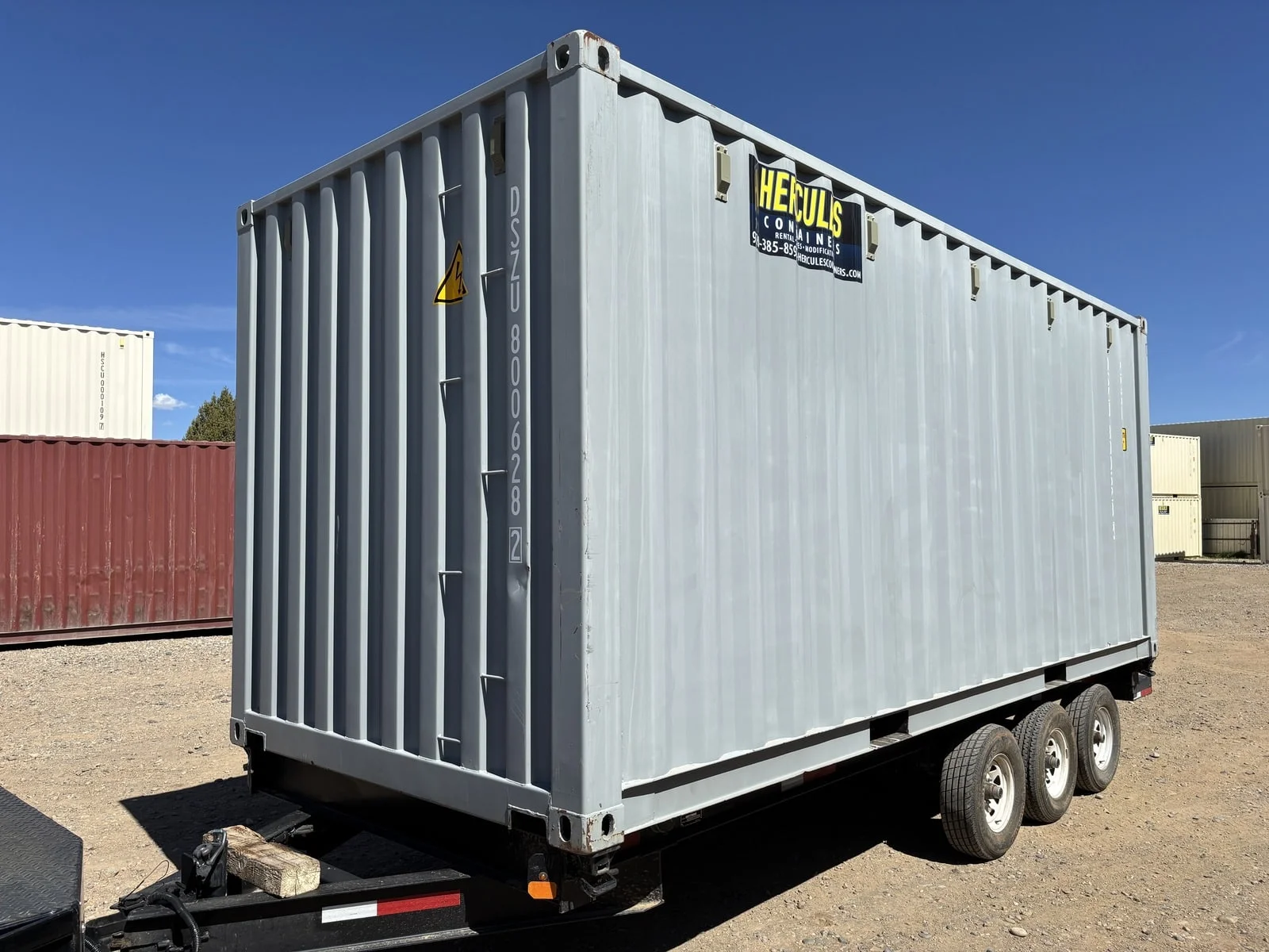 20-foot container loaded on a flatbed trailer for transport